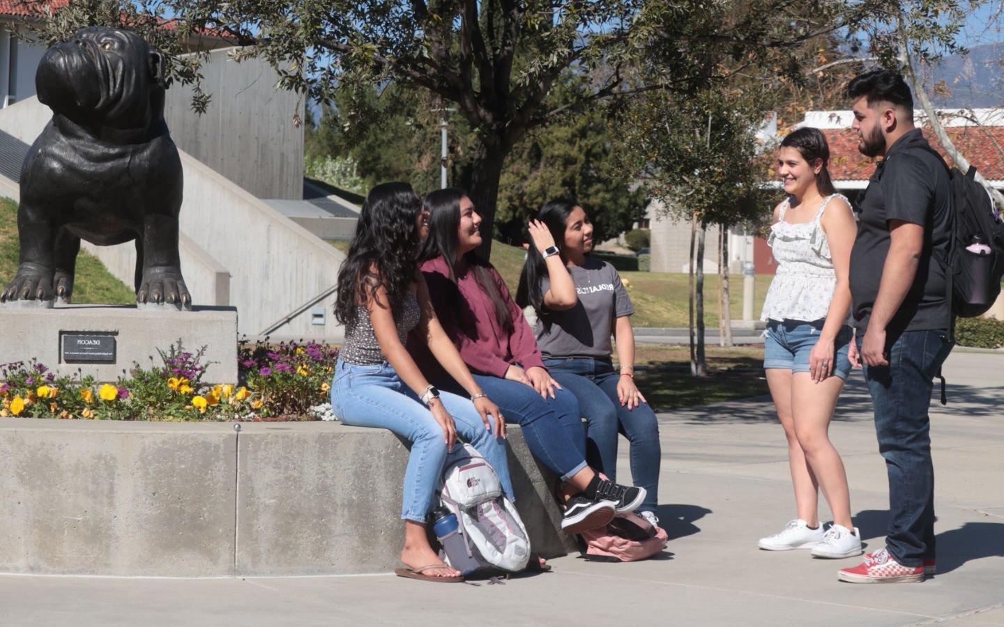 students talking near Bulldog statue